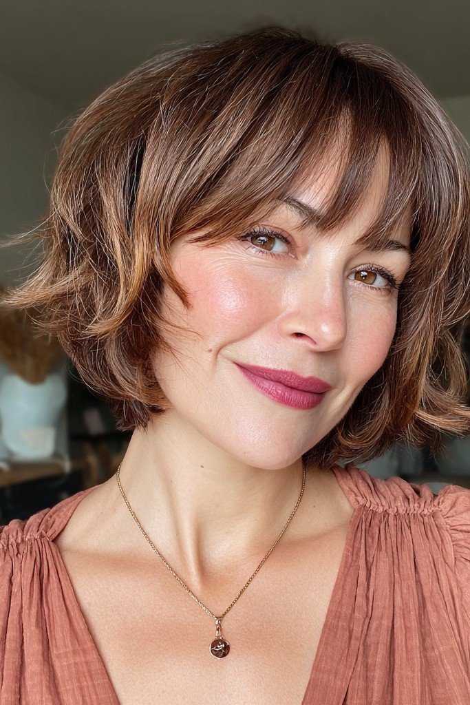 Layered Wavy Bob with Warm Highlights and Side-Swept Bangs