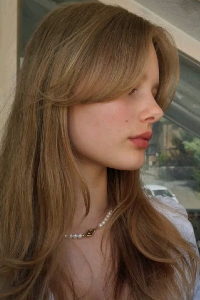 Long Layered Honey Blonde Hair with Face-Framing Curtain Bangs