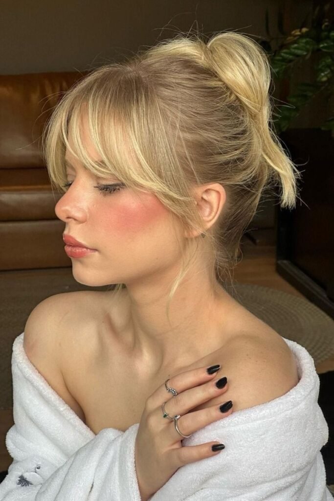Messy High Bun with Face-Framing Bangs
