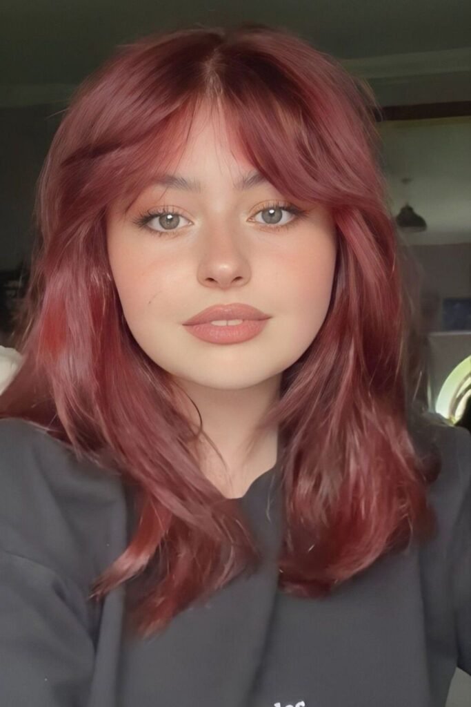 Mid-Length Layered Hair with Soft Reddish Tones and Curtain Bangs