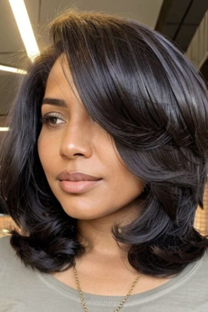 Smooth Jet Black Layered Bob with Side-Swept Curtain Bangs