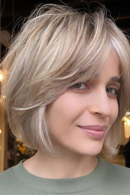 Voluminous Ash Blonde Feathered Bob with Layered Bangs