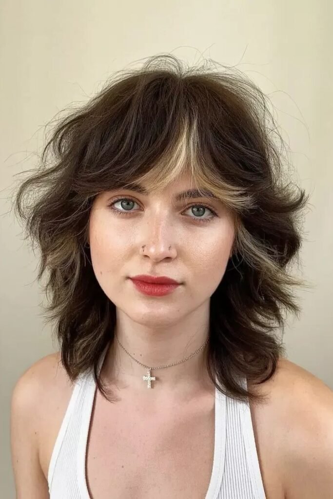 Medium Shaggy Haircut with Blonde Face-Framing Highlight