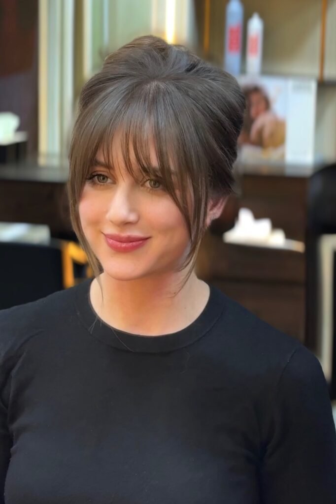 Updo with Blunt Bangs and Face-Framing Tendrils