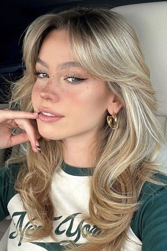 Voluminous Blonde Layered Haircut with Fluffy Curtain Bangs