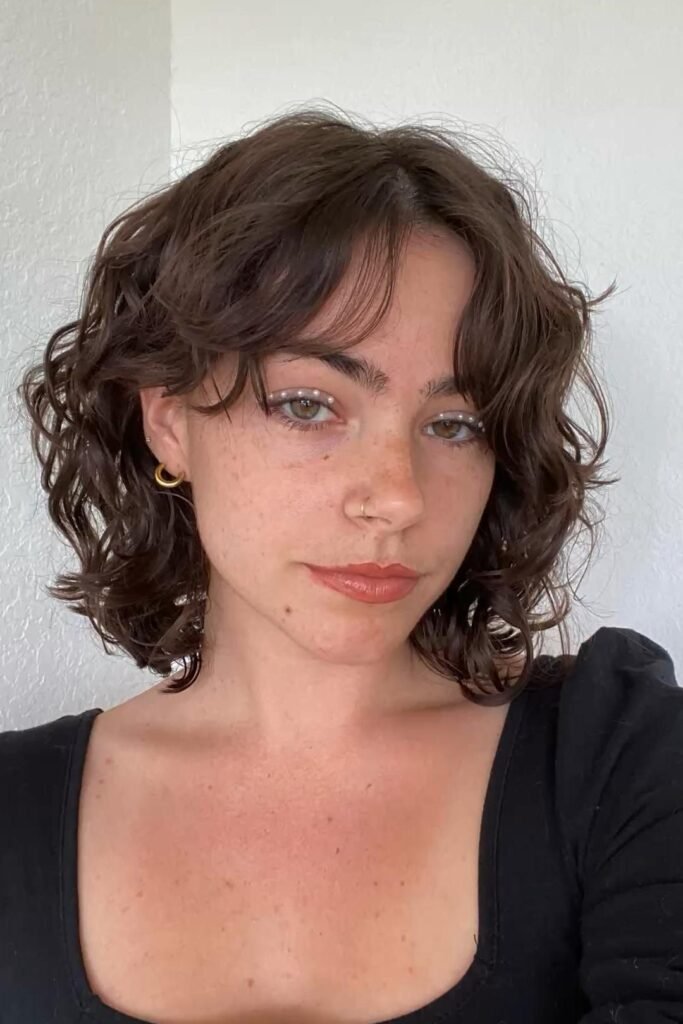 Wavy Bob with Center-Parted Curtain Bangs and Pearl Eye Makeup
